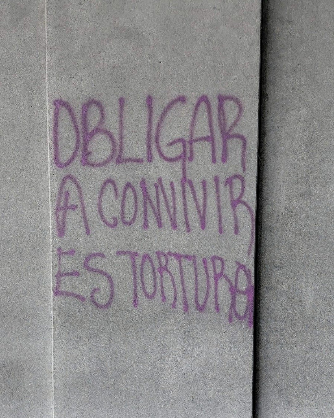 Pinta morada que dice Obligar a convivir es tortura.